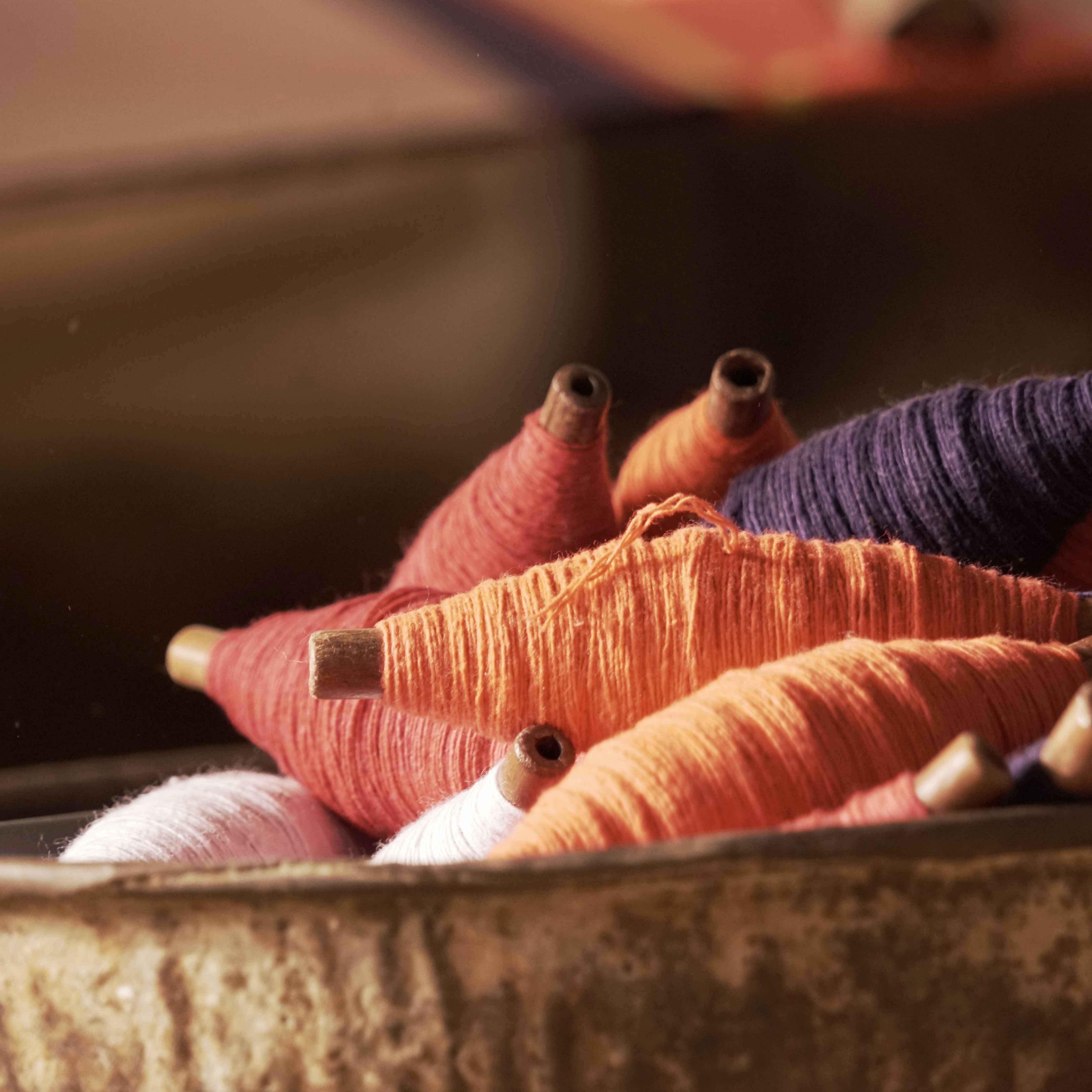 Handloom thread spools used in traditional weaving and heritage craft production in India.